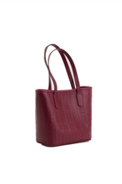 Maroon handbag with a textured pattern on a white background